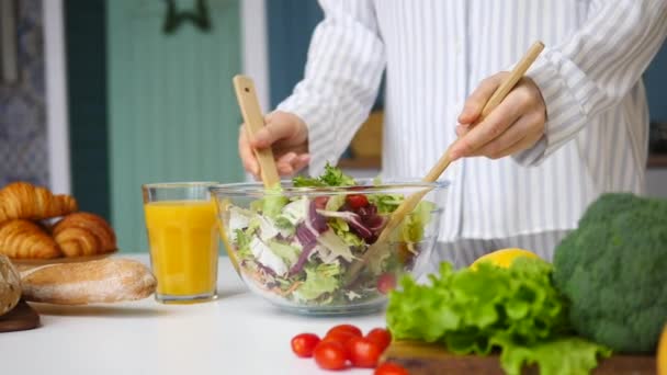 Közelkép a női kézről, amint összekeveri az egészséges salátát a konyhában. Lassú mozgás. — Stock videók
