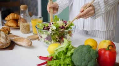 Mutfakta yeşil salata karıştıran kadın. Sağlıklı Yaşam ve Gıda Konsepti.