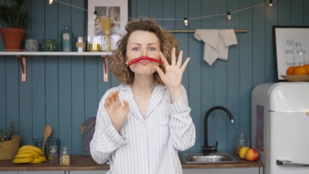 Retrato de mujer joven divertida con bigote de chile en la cocina — Vídeos de Stock