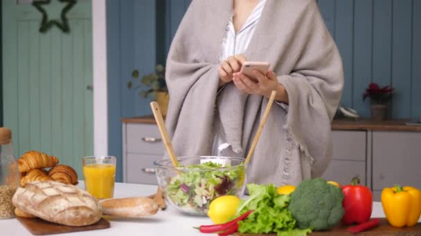 Жінка руки використовуючи смартфон приготування їжі на кухні . — стокове відео