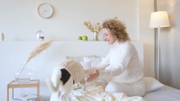 Concepto de familia feliz y estilo de vida. Mujer y perro en la cama . — Vídeo de stock