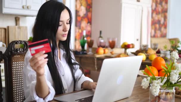 Νεαρή γυναίκα κρατάει πιστωτική κάρτα και χρησιμοποιεί φορητό υπολογιστή. Έννοια online αγορών. — Αρχείο Βίντεο