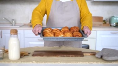 Yaşlı Kadın 'ın Yaşlı Elleri Taze kruvasanlarla Pişirme Tepsisi Tutuyor.