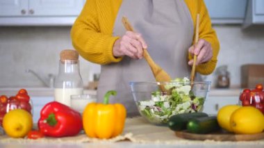 Mutfakta salata pişiren yaşlı kadının yakın çekim elleri. Sağlıklı Beslenme.