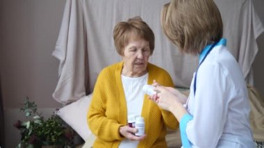 Doktor, kıdemli kadın hastaya evde reçete yazıyor..