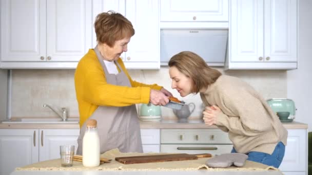 Büyükannem ve torunum mutfakta pasta pişiriyorlar. — Stok video