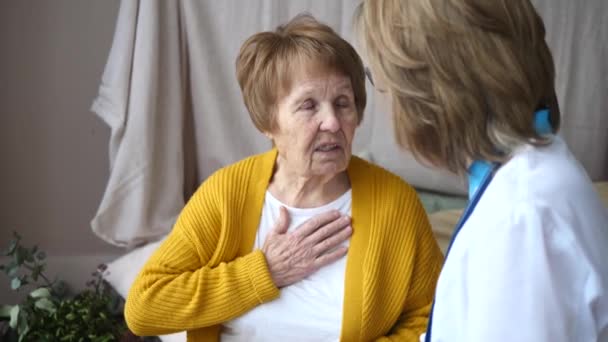 Mujer mayor paciente le dice al médico acerca de sus quejas de salud. Visitas al médico . — Vídeos de Stock