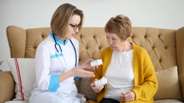 Médico de Medicina Femenino prescribiendo píldoras a una paciente mayor. Asistencia sanitaria . — Vídeo de stock