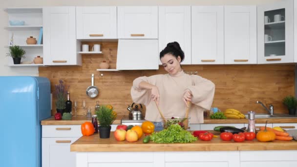 Giovane donna bruna che cucina sana insalata vegana a casa — Video Stock