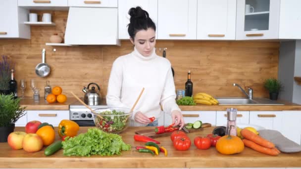 Mutfakta akşam yemeği için sağlıklı salata pişiren genç bir kadın.. — Stok video