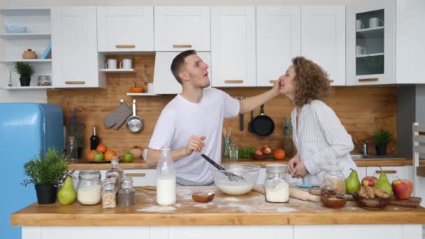 Glad familj par leker i köket medan matlagning frukost. — Stockvideo