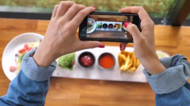 Yakından çekilen eller, kafede akıllı telefonlu yemek fotoğrafları çekiyor. Pov Vuruşu.