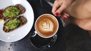 Woman Drinking Soy Coffee And Having Breakfast With Vegan Avocado Toast