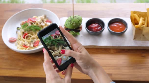 Mãos femininas fotografando alimentos com telefone inteligente no almoço — Vídeo de Stock