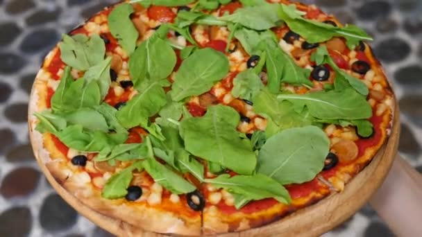 Primo piano della pizza vegana con formaggio, salsiccia di soia e rucola verde nelle mani — Video Stock
