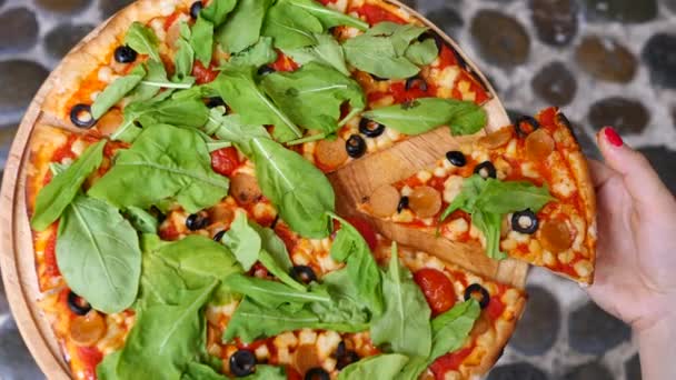 Eine weibliche Hand hält ein Stück kitschige vegane Pizza. Nahaufnahme. — Stockvideo