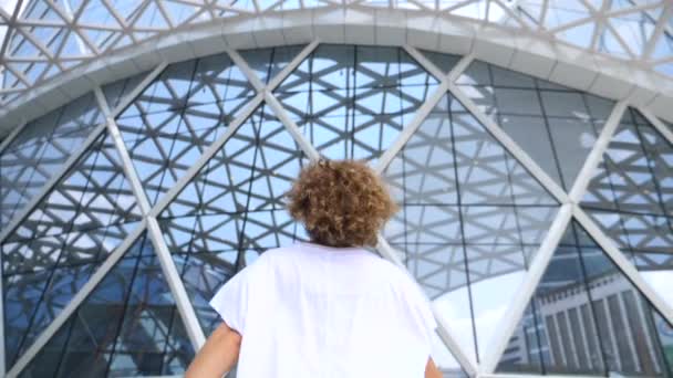 Jovem mulher arejada em vestido branco correndo na cidade contra fundo futurista urbano — Vídeo de Stock