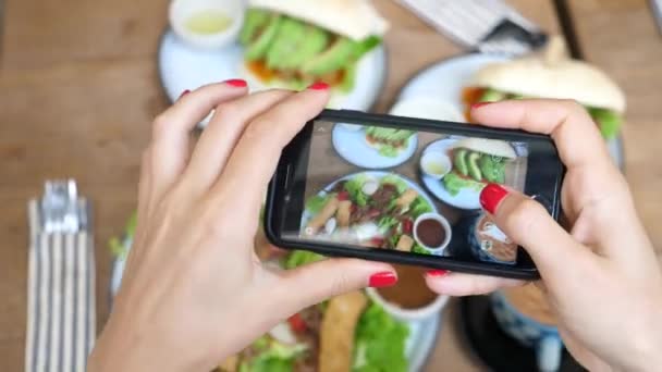 Fechar as mãos femininas tirando fotos de alimentos com smartphone no café saudável — Vídeo de Stock