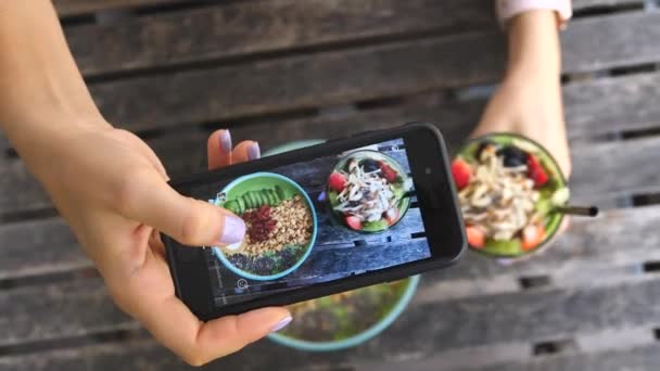 Жінки роблять фотографії вегетаріанської їжі зі смартфоном у здоровій кафе — стокове відео
