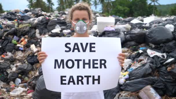 Miljöproblem. Kvinna på deponi webbplats med Spara Earth Poster — Stockvideo