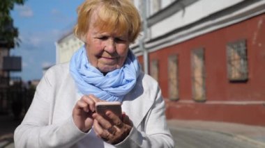 Cep telefonu kullanan yaşlı kadın. Yaşlılar ve Teknoloji Konsepti.
