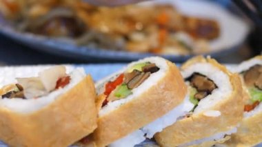 Chopsticks, Japon Lokantasında Vegan Suşi Üzerine Turşu Koyuyor.