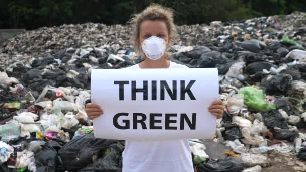 Mujer joven sosteniendo piensa cartel verde en basurero. Consumo excesivo . — Vídeo de stock