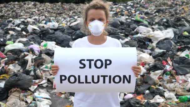 Nő kezében poszter Stop Pollution szlogen a szemétlerakóban. Öko-katasztrófa. — Stock videók