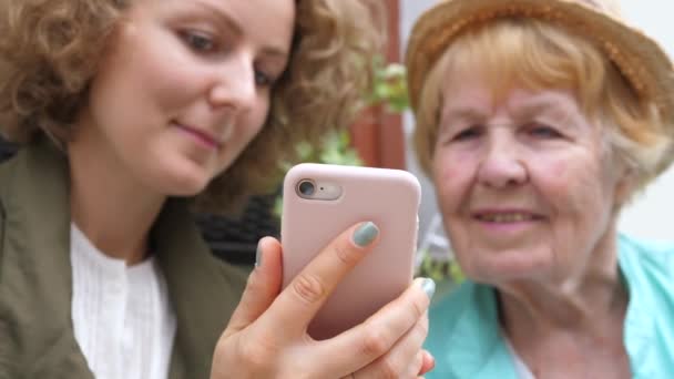 Nieta enseñando a la abuela cómo usar el teléfono inteligente — Vídeo de stock