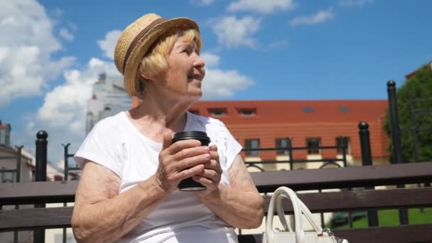 Mujer mayor descansando al aire libre en la ciudad con café para llevar — Vídeos de Stock