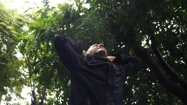 Homme heureux debout sous la pluie avec les bras tendus — Video