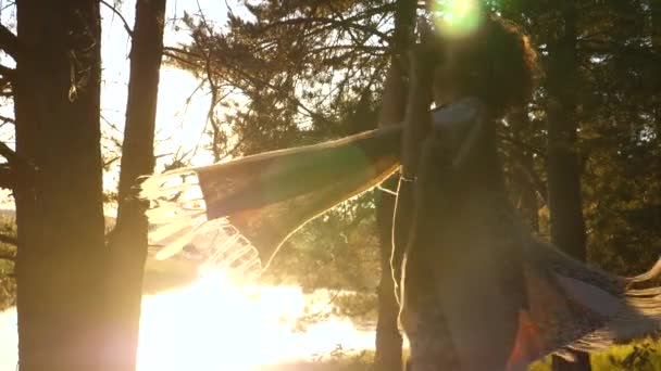 Glad ung kvinna dansar i skogen vid solnedgången på floden. — Stockvideo