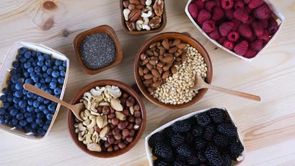 Frutos secos, semillas y bayas en la mesa de madera. Productos de supermercado . — Vídeo de stock