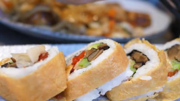 Bacchette che mettono lo zenzero sottaceto sul sushi vegano nel ristorante giapponese . — Video Stock