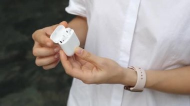 Airpods In Charging Case In Hand
