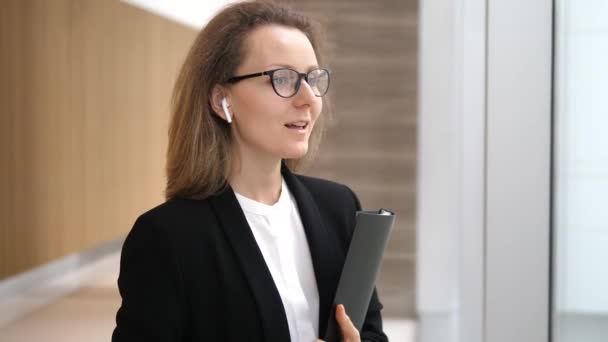 Mujer de negocios en auriculares inalámbricos hablando en el teléfono celular — Vídeo de stock