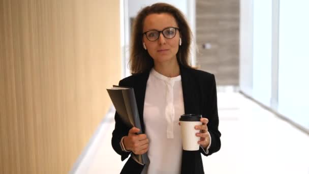 Уверенная деловая женщина, гуляющая с кофе в помещении — стоковое видео