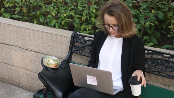 Mujer de negocios bebiendo café y trabajando en computadora portátil al aire libre — Vídeos de Stock