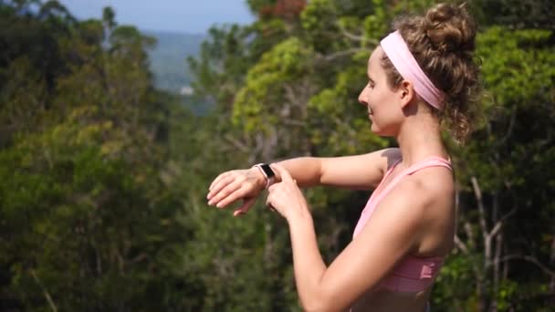 Deporte excursionista mujer usando smartwatch mientras senderismo en el bosque — Vídeo de stock