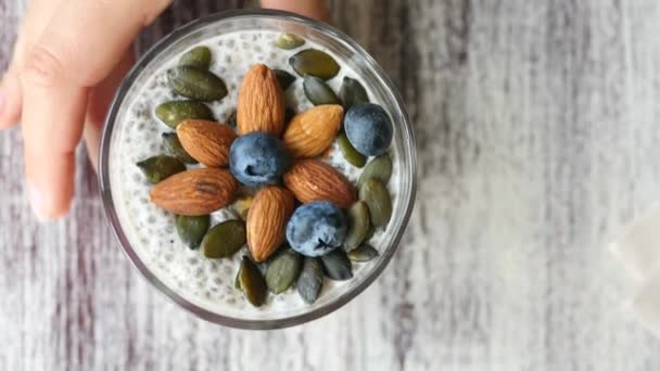 Zdravé chia semínko pudink ve sklenici s čerstvými bobulemi a ořechy — Stock video