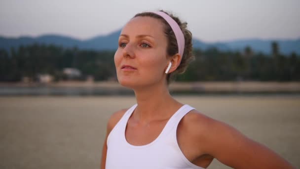 Active Healthy Lifestyle And Technology Concept (en inglés). Mujer en auriculares Bluetooth en la playa . — Vídeos de Stock