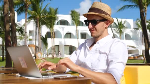 Mladý šťastný nezávislý muž pomocí notebooku na pláži práce na dálku — Stock video