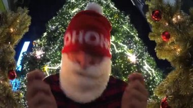 Noel ağacının yanında maytaplı mutlu Noel Baba portresi