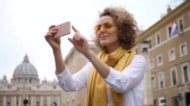 Avrupa 'da cep telefonuyla fotoğraf çeken genç bir kadın. Roma Tatili.