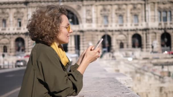 Gente, tecnología y concepto de vacaciones. Chica usando el teléfono celular caminando en la ciudad . — Vídeo de stock