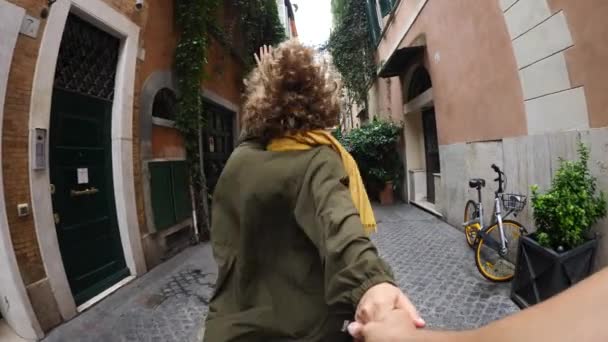 Mujer joven sosteniendo al hombre a mano en el centro de la ciudad vieja. Viajar juntos y seguirme Concepto . — Vídeos de Stock