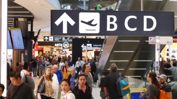 Концепция туризма и путешествий. Пассажиры с багажом ищут ворота в терминале аэропорта. Рим, Италия, 10 октября 2018 г. . — стоковое видео
