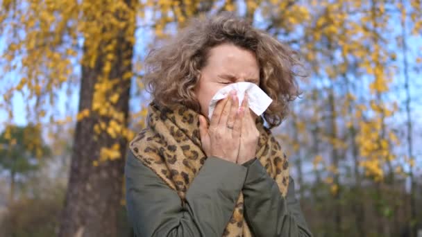 Mujer estornudando con tejido teniendo gripe o alergia al aire libre — Vídeo de stock