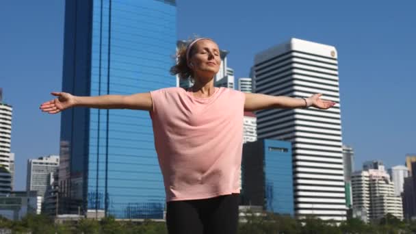 Sportovkyně zvedající paže k obloze cvičení a cvičení venku ve městě — Stock video