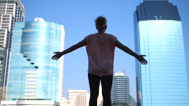 Silhuett av Sportswoman höja armarna till himlen njuter City View — Stockvideo